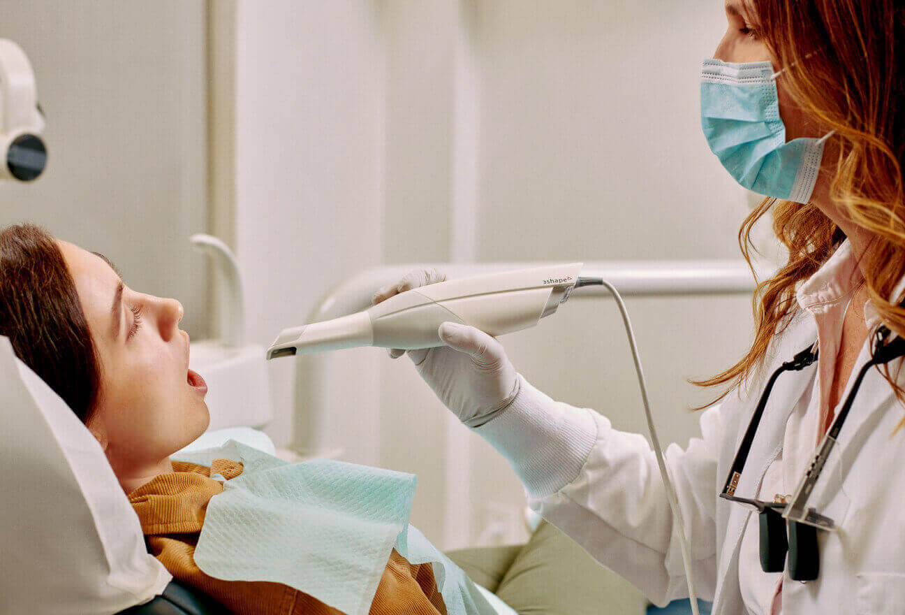 Dentista realizando un escaneo intraoral a un paciente